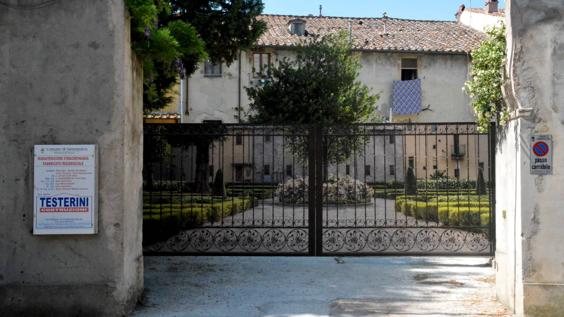 Cancello in ferro battuto con cartello di cantiere Testerini Costruzioni