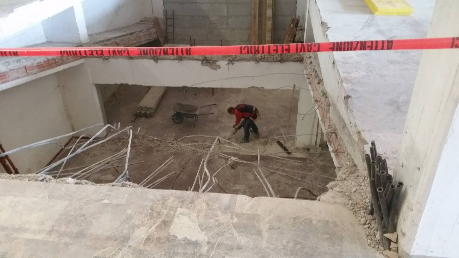 Interni in fase di demolizione con operai e nastri di segnalazione