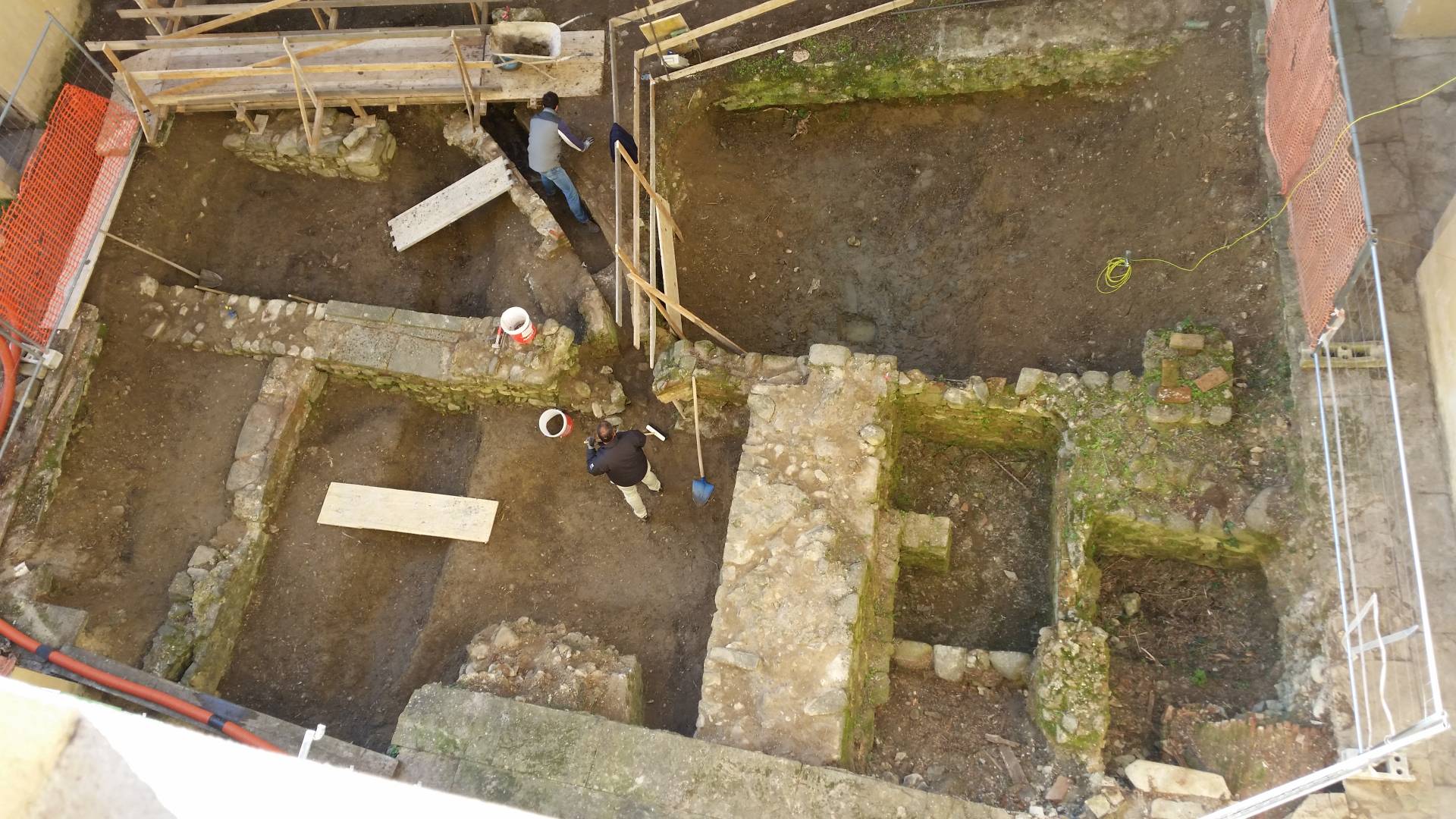 Vista dall'alto degli scavi archeologici e delle fondamenta con operai al lavoro